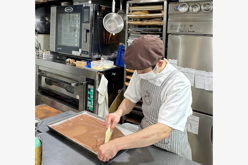 キッチンに設置されているウノックス スチームコンベクションオーブン BAKERTOPと生地を加工しているパティシエの方の様子
