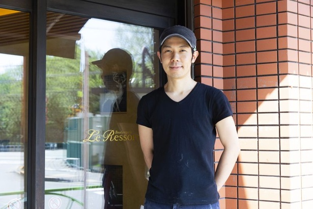 店主の清水宣光シェフが店の名前が入った扉の前に立っている様子